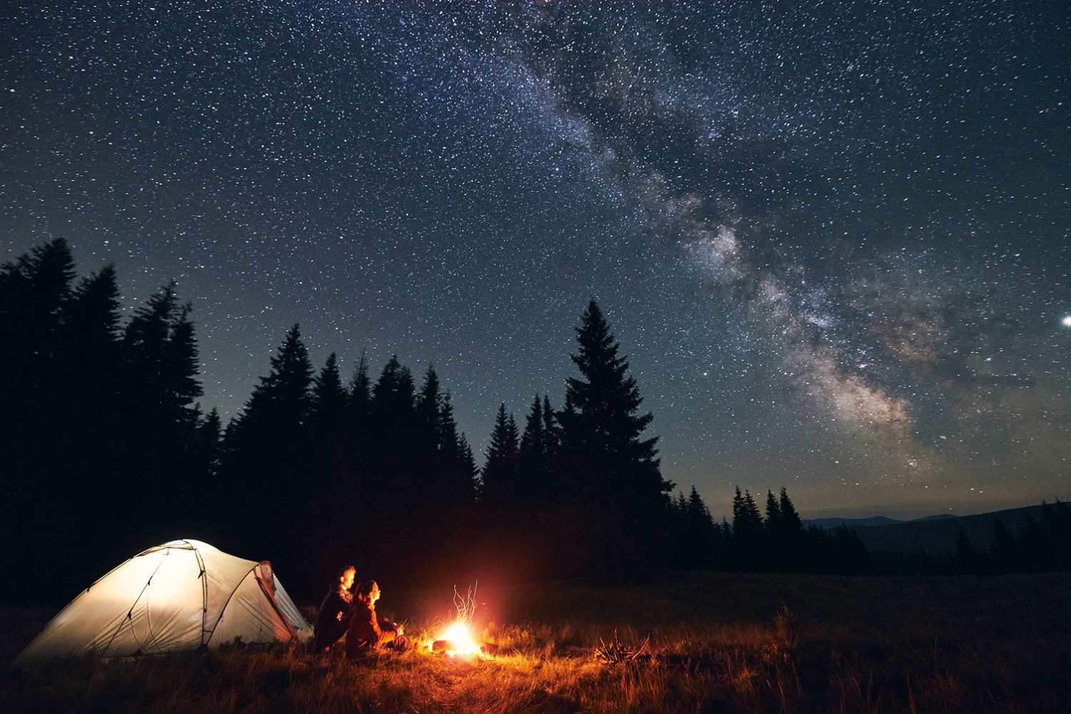 Couple qui campent en pleine nature admirant les étoiles