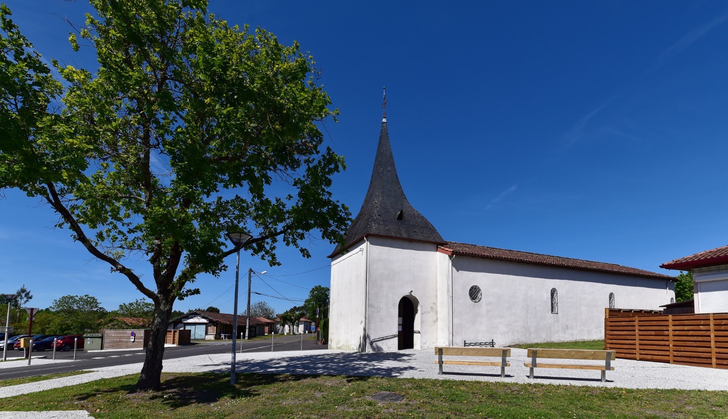 Église Saint-Jean de Vielle à Vielle-Saint-Girons avec clocher torsadé, sous un ciel bleu, typique du patrimoine architectural des Landes